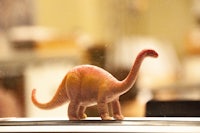a toy dinosaur standing on top of a table