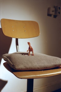 a small toy dinosaur on a chair